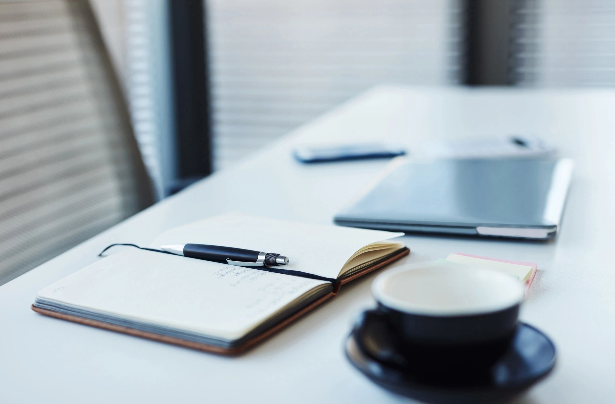 Notebook and laptop on a desk, representing website settings and preferences